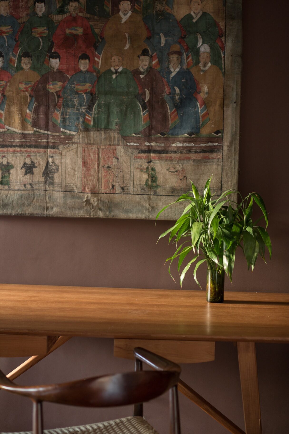 Dining table beneath an antique tapestry